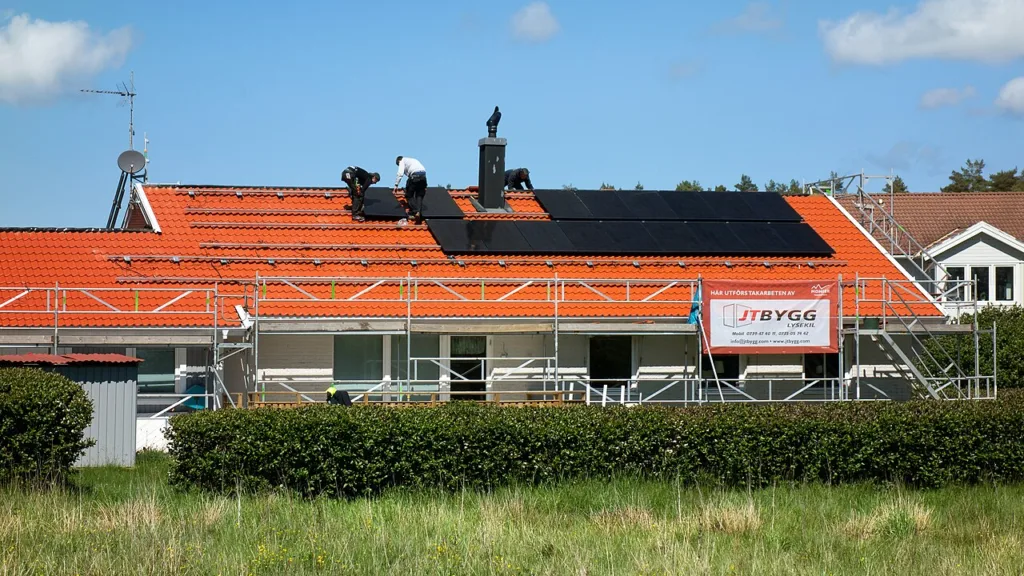 Technicians installing solar panels on a residential roof