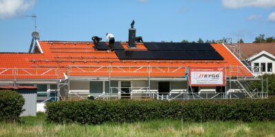 Technicians installing solar panels on a residential roof