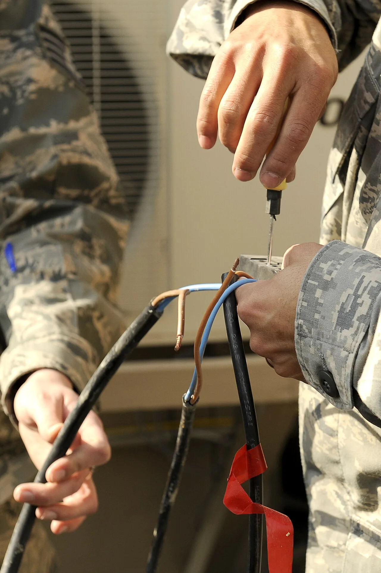 u s airmen works on the wiring of a solar powered light